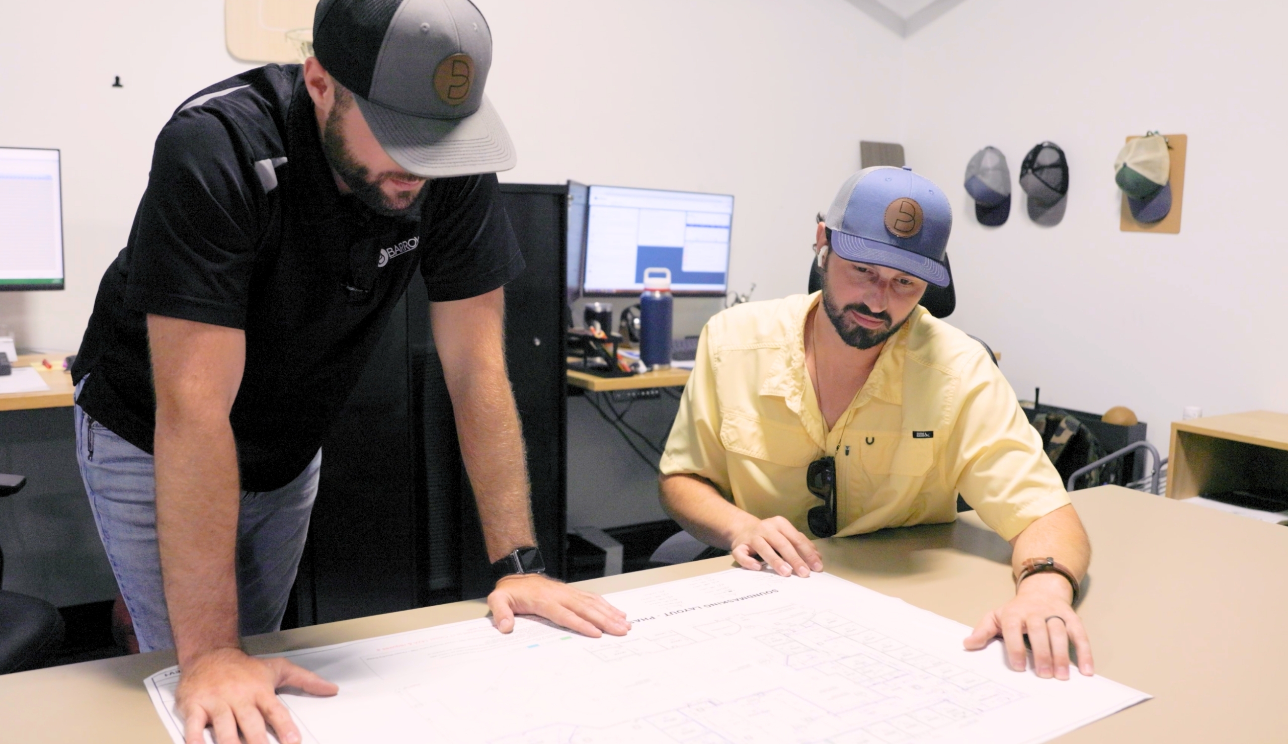two men at work looking at a floor plan